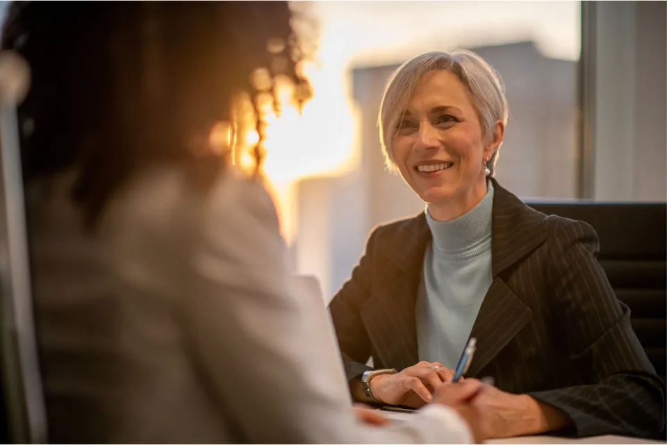 An executive coach listening to a senior leader during a one-to-one session